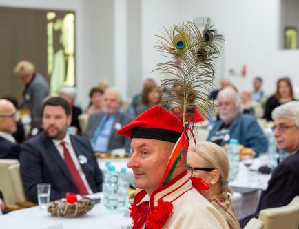 Członek zespołu siedzący za stołem w folkowym ubraniu