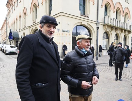 Kolorowa fotografia. Dwóch mężczyzn stojących na placu Szczepańskim